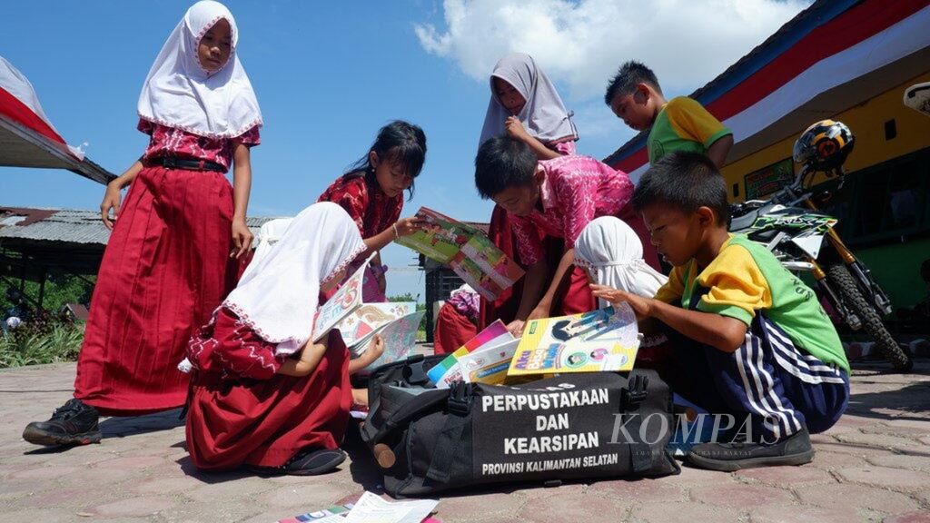 Siswa-siswi SD Negeri Pulau Alalak memilih buku bacaan dari motor <i>trail </i>perpustakaan keliling yang menyambangi sekolah mereka di Desa Pulau Alalak, Kecamatan Alalak, Kabupaten Barito Kuala, Kalimantan Selatan, Kamis (22/8/2019).