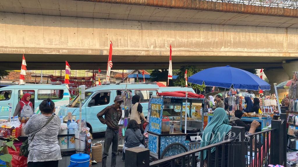 Penjual makanan yang berada di samping kendaraan berlalu lalang di kawasan Stasiun Tanah abang, Jakarta Pusat, Kamis (10/8/2023).