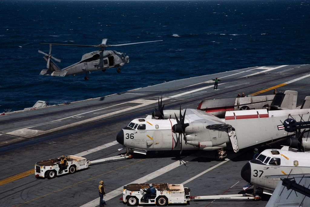 Sebuah helikopter Angkatan Laut AS, MH-60S Hawk (kiri), tiba untuk mendarat saat sebuah C-2 Grayhound bersiap di dek penerbangan kapal induk USS Nimitz di lepas pantai Busan, Korea Selatan, 27 Maret 2023. Latihan bersama militer AS dan Korea Selatan bertajuk Ssangyong berlangsung hingga 3 April sebagai bagian dari latihan perang Warrior Shield. 