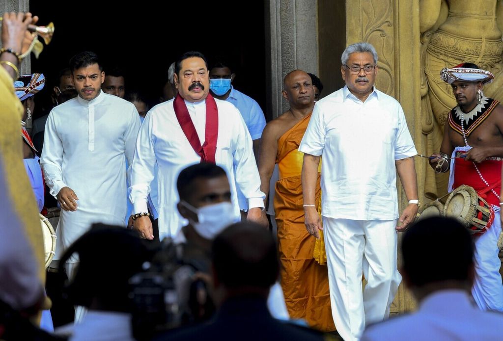 Presiden Sri Lanka Gotabaya Rajapaksa (kanan) dan Perdana Menteri Sri Lanka Mahinda Rajapaksa (tengah) berjalan bersama usai upacara pengambilan sumpah di Candi Budha Kelaniya Mahaviharaya, luar Kota Kolomobo, 9 Agustus 2020. (Photo by Ishara S. KODIKARA / AFP)