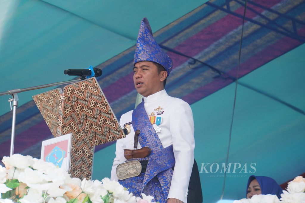 Bupati Bolaang Mongondow Timur Sam Sachrul Mamonto mengikuti upacara bendera di halaman kantor bupati, Kamis (21/7/2022), di Tutuyan, Bolaang Mongondow Timur, Sulawesi Utara, dalam perayaan hari jadi ke-14 kabupaten tersebut.