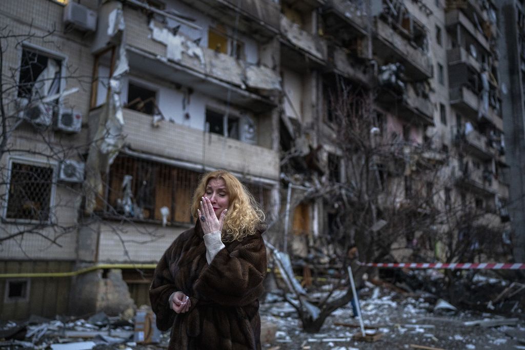 Natali Sevriukova menyaksikan tempat tinggalnya yang dihantam roket di Kiev, Ukraina, 25 Februari 2022. 