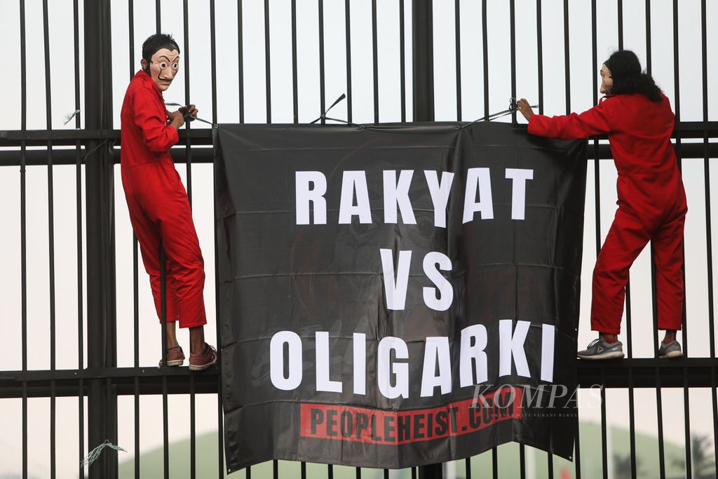 Spanduk yang dibawa aktivis People Heist saat berunjuk rasa di depan Gedung Parlemen, Senayan, Jakarta, Senin (4/10/2021). Mereka, antara lain, menyuarakan dan memperingatkan perihal bahaya oligarki yang semakin merejalela, khususnya pasca-pengesahan Undang-Undang Cipta Kerja. 