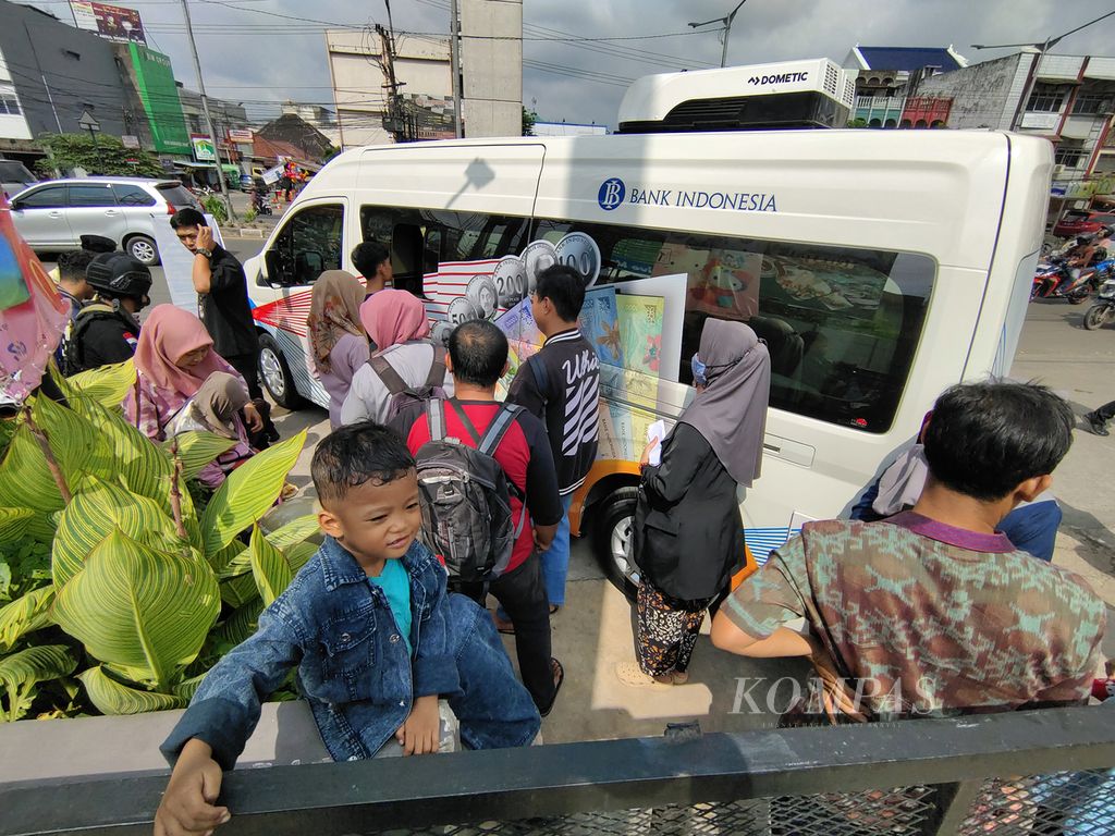 Warga mengantre untuk menukarkan uang melalui mobil kas keliling Bank Indonesia Kantor Perwakilan Sumatera Selatan di Pasar Palimo, Palembang, Sumsel, Kamis (21/3/2024). 