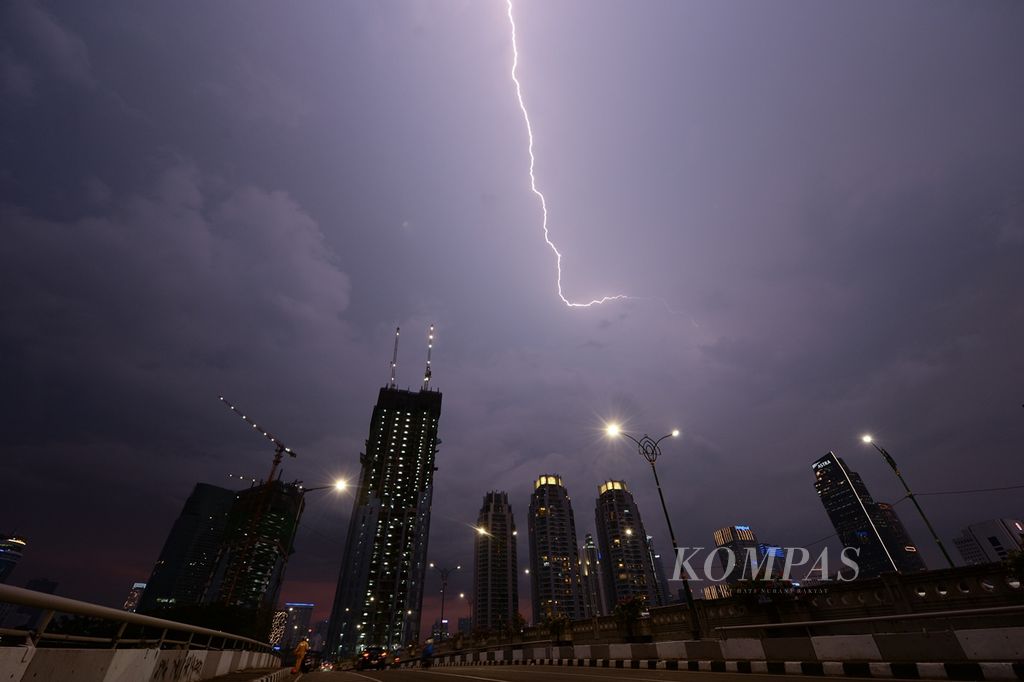 Sesaat sebelum diguyur hujan, awan hitam disertai kilatan petir menghiasi langit di kawasan Kuningan, Jakarta, Sabtu (30/11/2019).