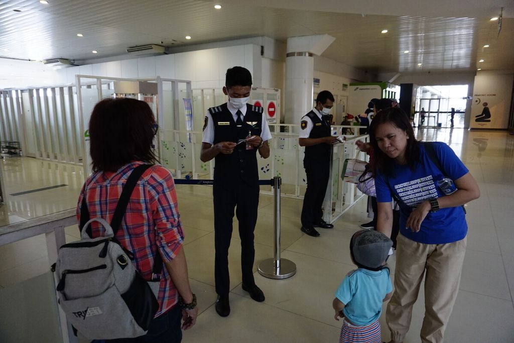 Petugas di Bandara Sultan Aji Muhammad Sulaiman Sepinggan, Balikpapan, mengenakan masker saat memeriksa tiket penumpang di Balikpapan, Kalimantan Timur, Senin (27/1/2020).