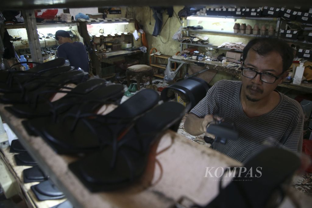 Pekerja menyelesaikan pembuatan alas kaki wanita di sebuah industri pembuatan alas kaki OB Shoes di Pondok Benda, Tangerang Selatan, Banten, Rabu (20/10/2020). 