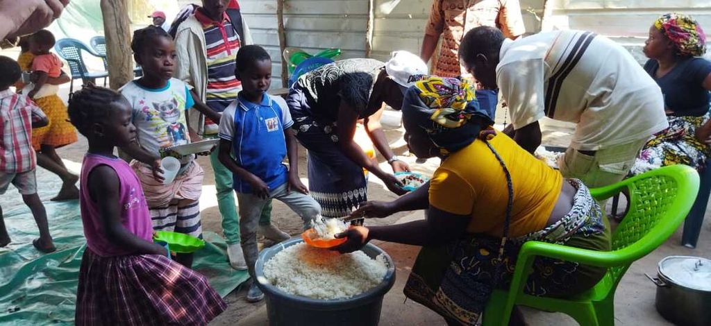 Memberi makan anak-anak yatim piatu dan fakir miskin di Mozambik bersama kaum ibu setempat.