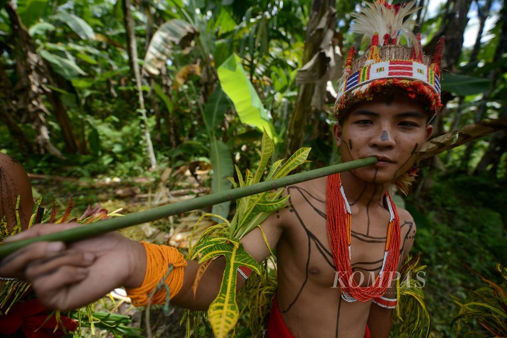 Benediktus (14) meniup <i>popoet</i> (seruling bambu) di Festival dan Pagelaran Budaya Mentawai di Desa Madobag, Kecamatan Siberut Selatan, Kabupaten Kepulauan Mentawai, Sumatera Barat, Sabtu (30/7/2022). 