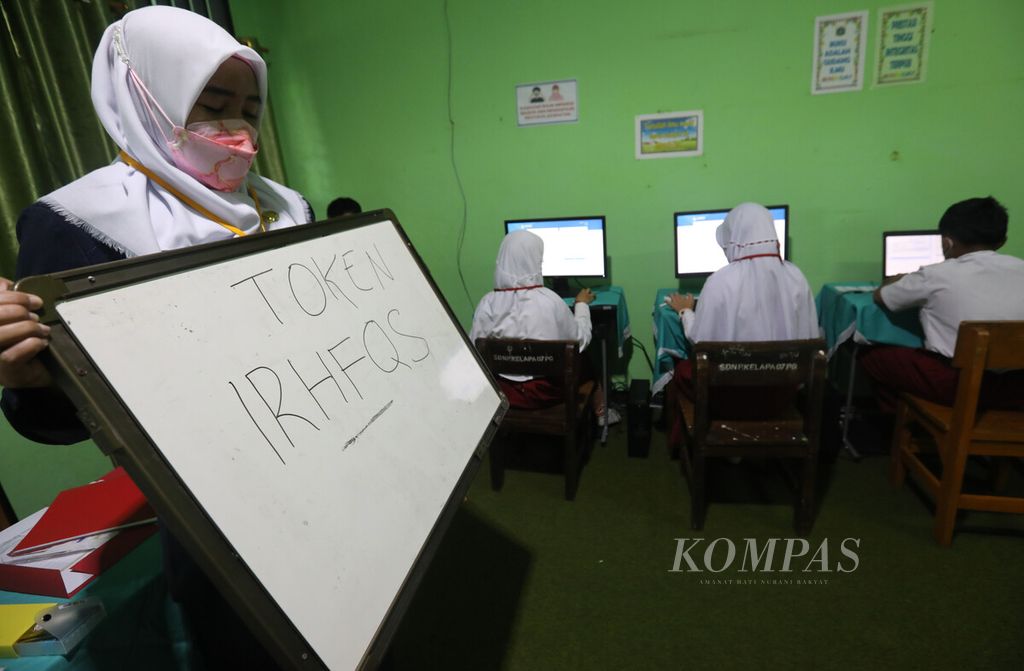 Pengawas mengumumkan kode token yang digunakan siswa SDN 07 Pondok Kelapa, Jakarta saat mengikuti asesmen nasional berbasis komputer (ANBK) di sekolahnya, Senin (24/10/2022). 