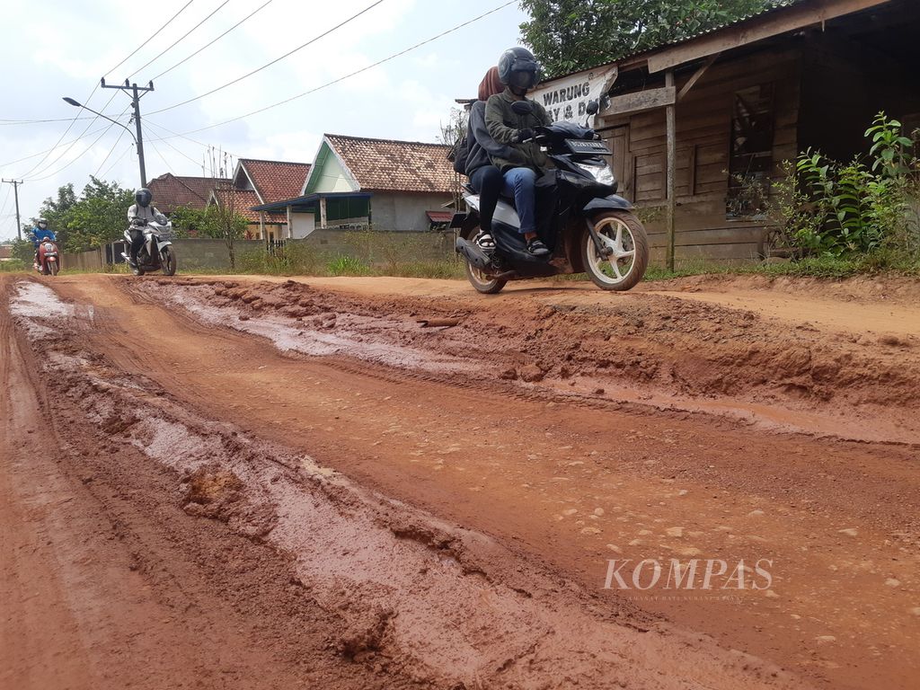 Pengendara melewati jalan rusak di Kecamatan Pangkalan Lampam, Kabupaten Ogan Komering Ilir, Sumatera Selatan, Selasa (23/5/2023). Kerusakan jalan disebabkan banyaknya kendaraan bertonase berat melewati jalur ini.