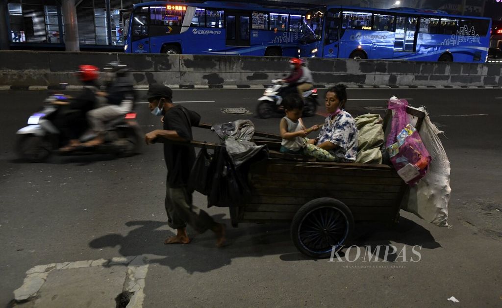 Pemulung menarik gerobak di kawasan Harmoni, Jakarta Pusat, pada malam takbiran, Rabu (12/5/2021). 