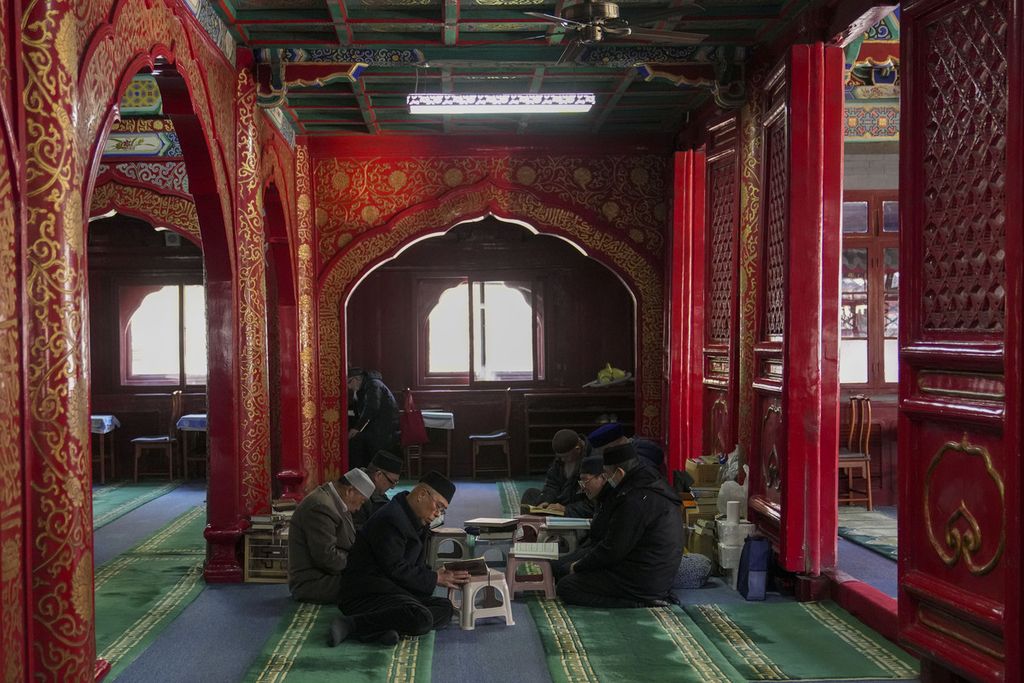 Warga Muslim di China membaca Al Quran sambil menunggu waktu berbuka puasa pada hari pertama Ramadhan di Masjid Niujie di Beijing, China, 12 Maret 2024. 