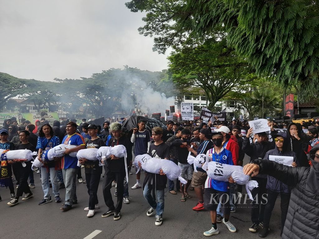 Seribuan Aremania, Kamis (27/10/2022), kembali turun ke jalan. Mereka menggelar aksi damai di depan Balai Kota Malang, Jawa Timur, menuntut proses hukum hingga tuntas kasus tragedi Kanjuruhan yang menewaskan 135 orang dan melukai lebih dari 650 orang lainnya.