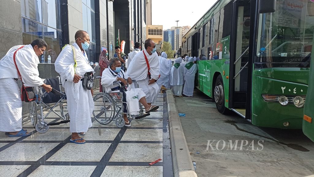Dua anggota jemaah haji dengan kursi roda bersiap untuk naik ke bus "Sholawat" di Raudah, Mekkah, Arab Saudi, Minggu (19/6/2022). Bus itu akan mengantar jemaah haji ke Masjidil Haram.