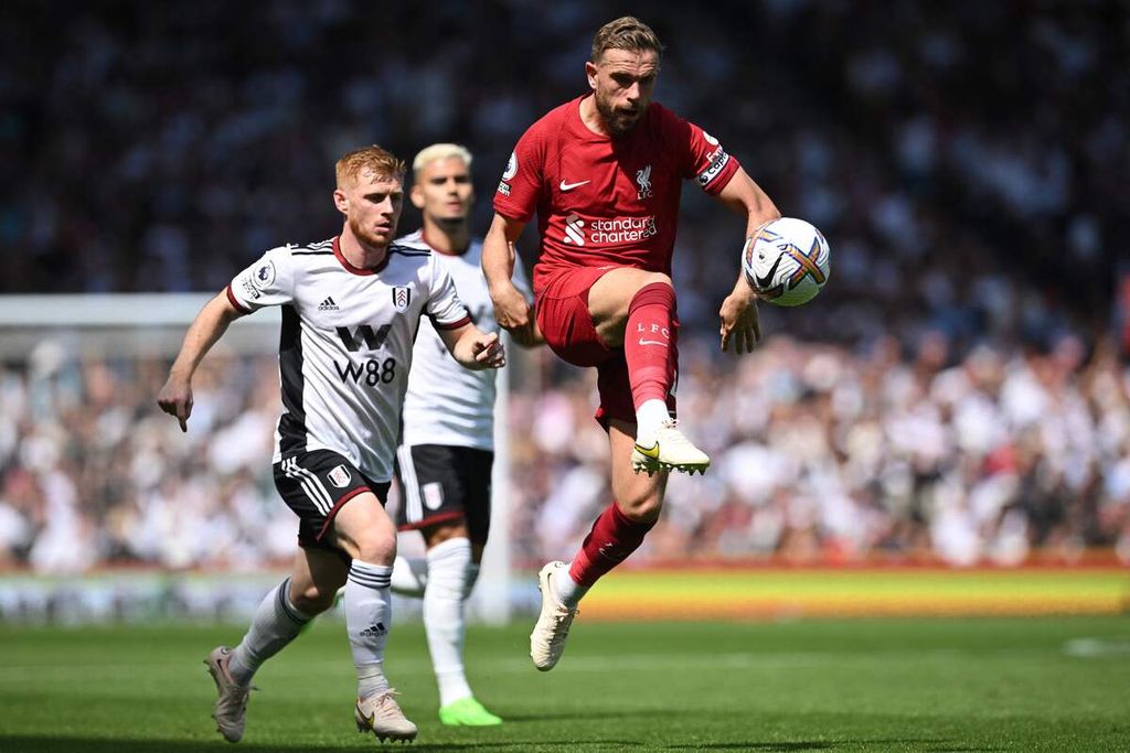 Gelandang Liverpool, Jordan Henderson (kanan), menggiring bola dalam pertandingan Liga Inggris antara Fulham dan Liverpool di Stadion Craven Cottage, Fulham, Sabtu (6/8/2022). Pertandingan berakhir imbang, 2-2. 
