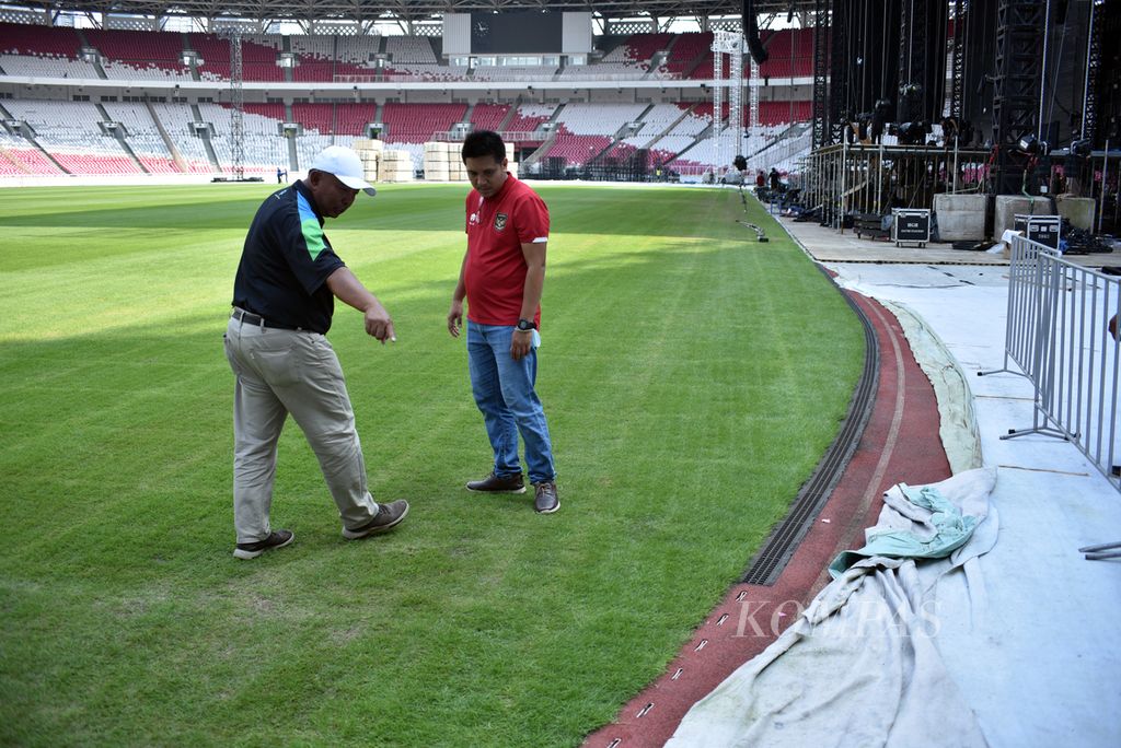 Kontraktor persiapan lapangan di enam kota Piala Dunia FIFA U-20 2023 Qamal Mutaqin (kiri) mengecek rumput Stadion Utama Gelora Bung Karno di Jakarta, Senin (13/3/2023), sesudah dipakai untuk konser musik akhir pekan lalu. 