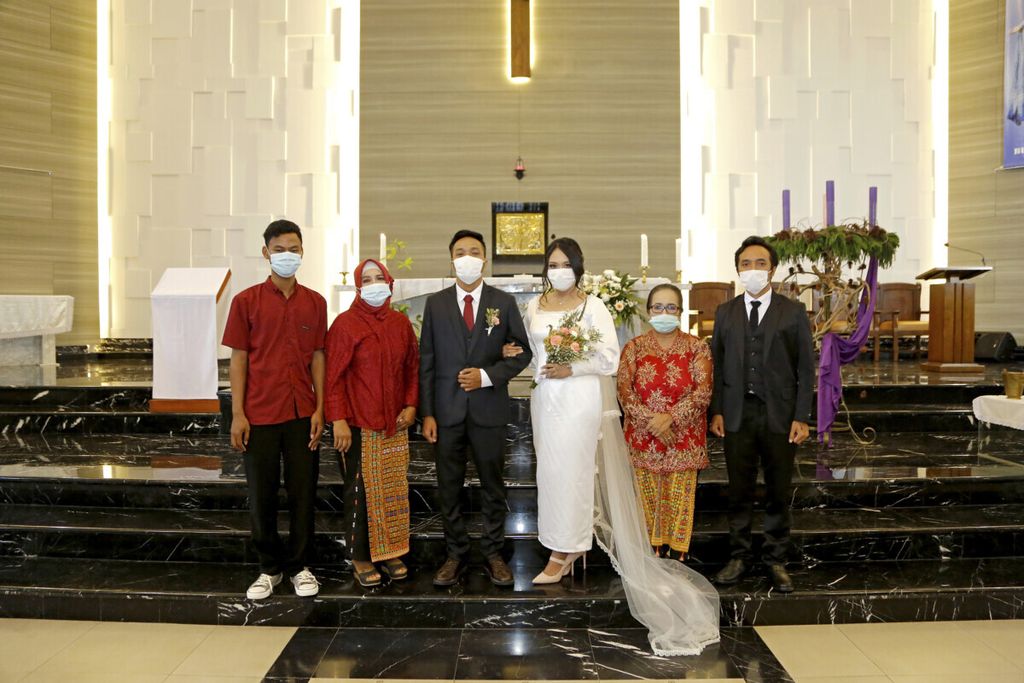 Keluarga berfoto dengan pengantin di dalam gereja seusai pemberkatan, Jumat (4/12/2020). Meski berbeda agama, pernikahan menyatukan mereka.