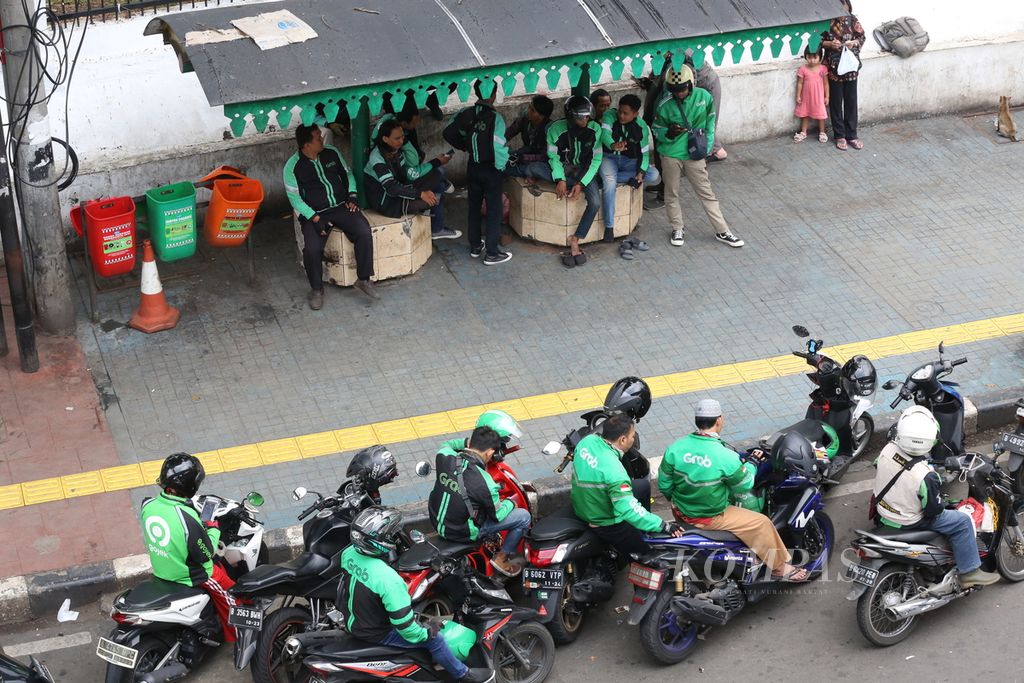 Ojek <i>online</i> menunggu orderan penumpang di sekitar Stasiun Palmerah, Jakarta, 22 Januari 2020. 