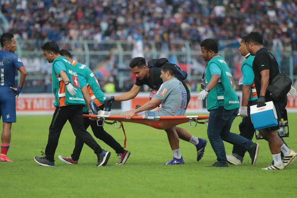 Pemain Persib Bandung diusung keluar lapangan karena cedera dalam lanjutan Shopee Liga I/2020, Minggu (08/03/2020) di Stadion Kanjuruhan Malang, Jawa Timur. Laga berakhir dengan skor 1-2 untuk keunggulan Persib Bandung.