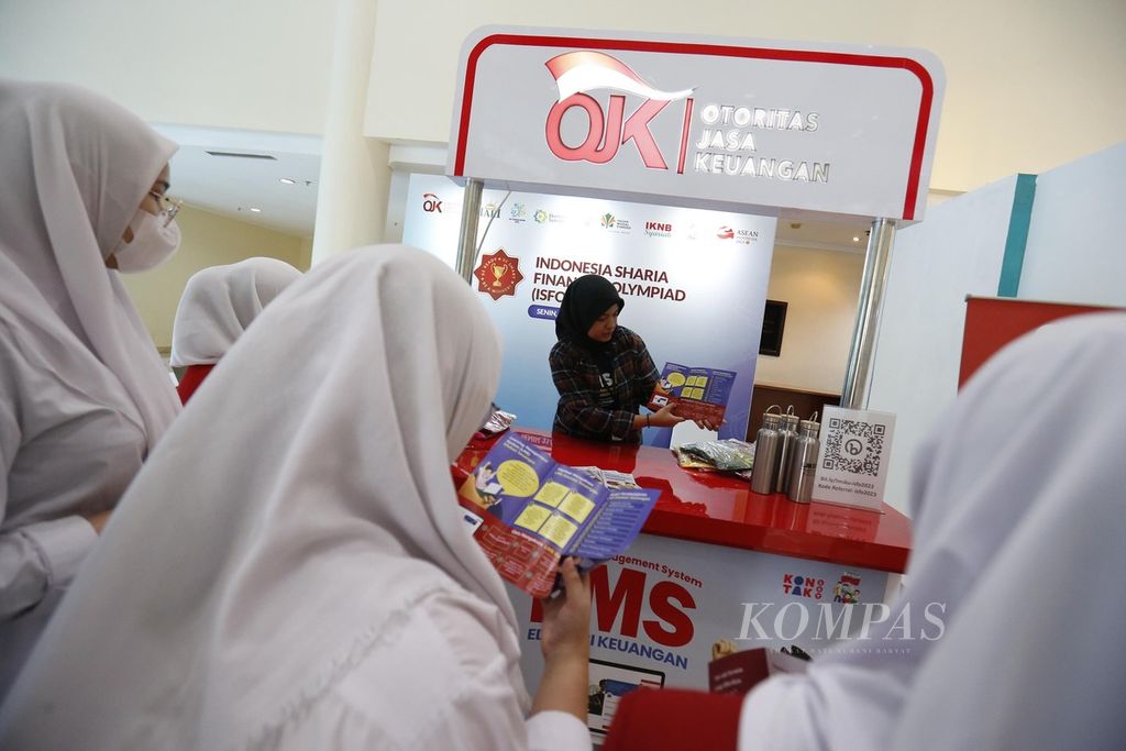 Pelajar mendengarkan penjelasan dari petugas stan OJK tentang literasi dan inklusi keuangan di Jakarta, Senin (22/5/2023). 