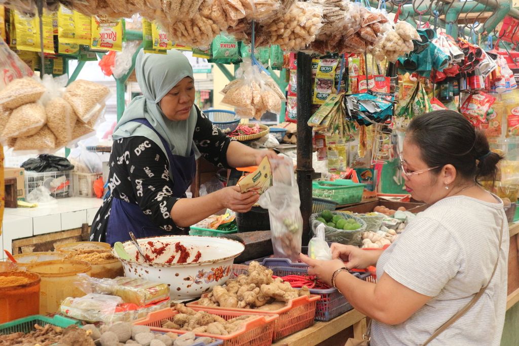 Pembeli membungkus belanjaan pembeli dalam kantong plastik di Pasar Cidodol, Jakarta Selatan, Selasa (4/10/2022).