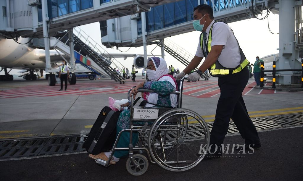 Jemaah haji Kloter 1 Debarkasi Surabaya yang baru turun dari pesawat Saudi Arabia Airlines menggunakan kursi roda karena mengalami kesulitan berjalan di Terminal 2 Bandara Internasional Juanda Surabaya di Kabupaten Sidoarjo, Jawa Timur, Minggu (17/7/2022).