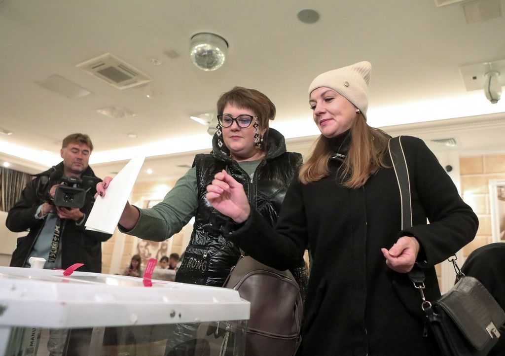 Dua orang perempuan warga dari wilayah yang dikontrol Rusia dan kini tinggal di Moskwa memberikan suara dalam referendum yang digelar sejak Jumat (23/9/2022) lalu. Perempuan-perempuan itu memberikan suara di sebuah tempat pemungutan suara di Moskwa pada Selasa (27/9/2022).