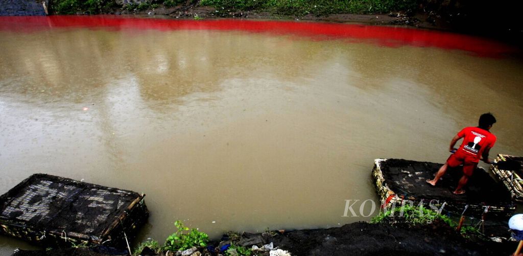 Pencari pasir di Sungai Citarum yang melintasi Majalaya, Bandung, Jawa Barat, beraktivitas di sekitar sungai yang airnya tercemar limbah pabrik tekstil (warna merah), Selasa (22/3). 