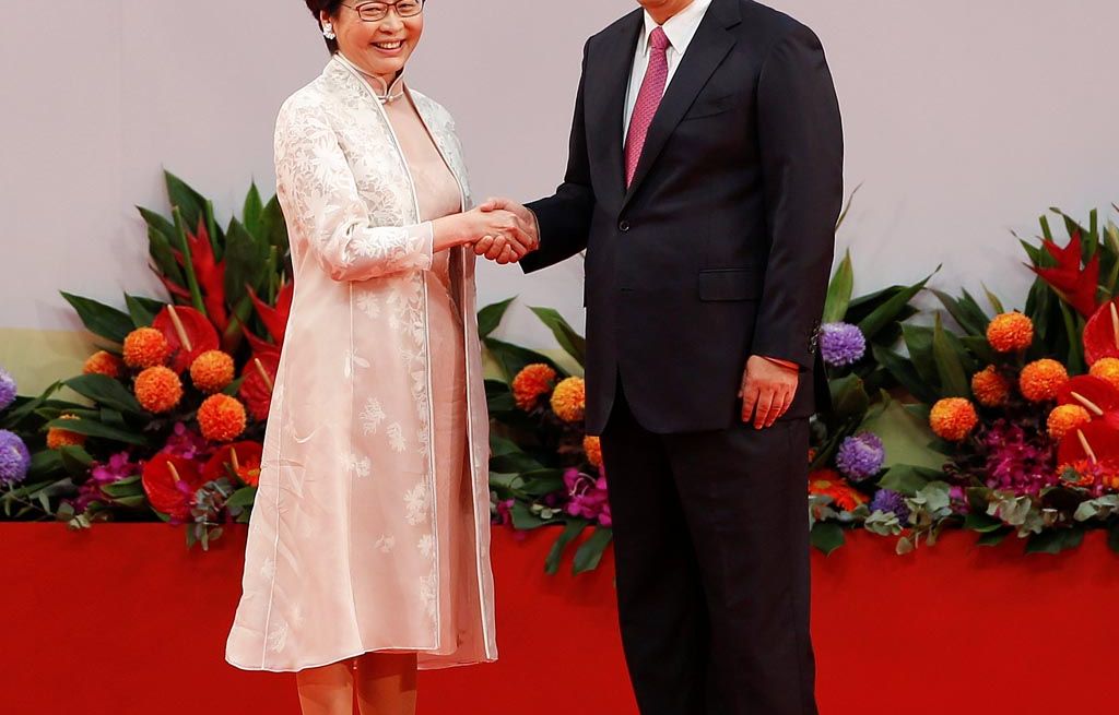 Pemimpin Hongkong Carrie Lam (kiri) dan Presiden China Xi Jinping  berjabat tangan  setelah acara pengambilan sumpah Lam sebagai pemimpin baru wilayah tersebut, Sabtu (1/7). 