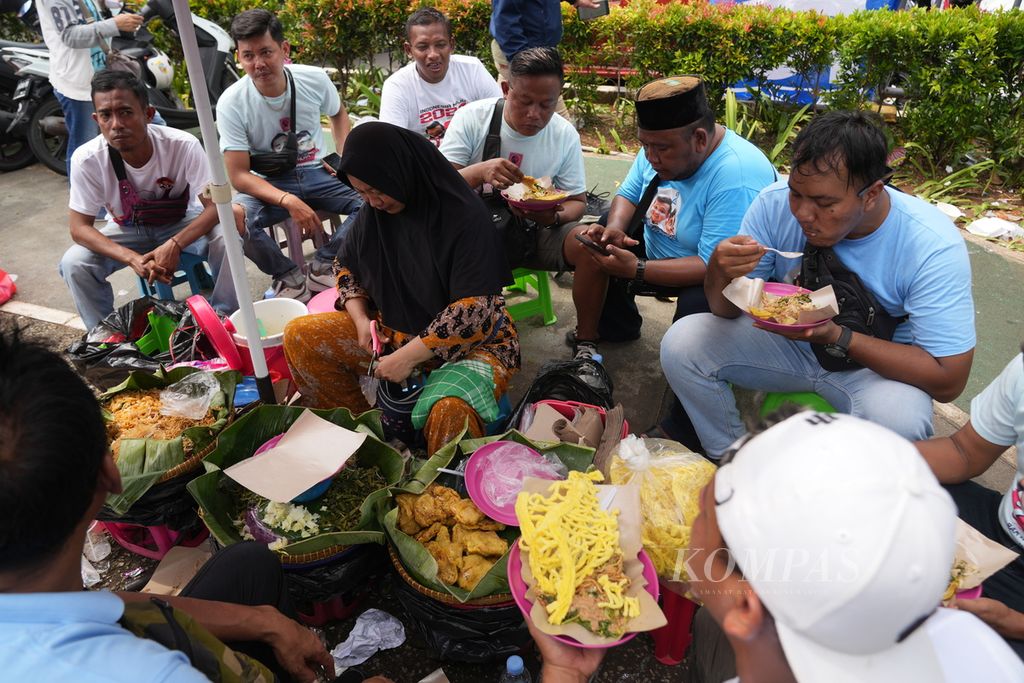 Pendukung capres-cawapres Prabowo Subianto-Gibran Rakabuming Raka makan pecel sebelum mengikuti kampanye terbuka Pesta Rakyat untuk Indonesia Maju di Stadion Utama Gelora Bung Karno, Jakarta, Sabtu (10/2/2024). 