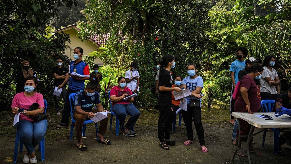 Warga antre untuk menjalani vaksinasi Covid-19 di Sungai Buloh, Selangor, Malaysia, Senin (28/6/2021).