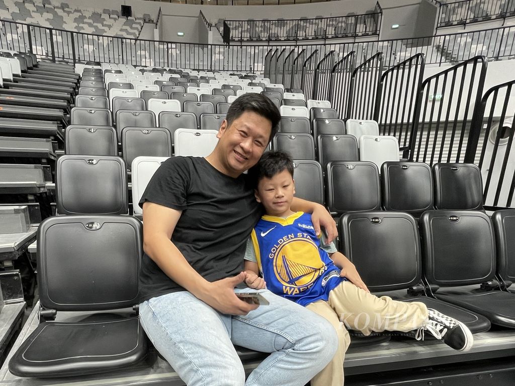 Andre Rinaldi (40) dan anaknya, Karsten (6), menonton laga Invitasi Bola Basket Internasional Indonesia (IIBI) antara timnas bola basket Indonesia melawan Indonesia Patriots di Indonesia Arena, Jakarta, Rabu (2/8/2023). 
