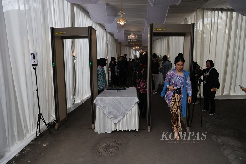 Tamu undangan melewati alat deteksi besi setelah menghadiri prosesi siraman Erina Gudono di Desa Sinduadi, Mlati, Sleman, DI Yogyakarta, Jumat (9/12/2022). 
