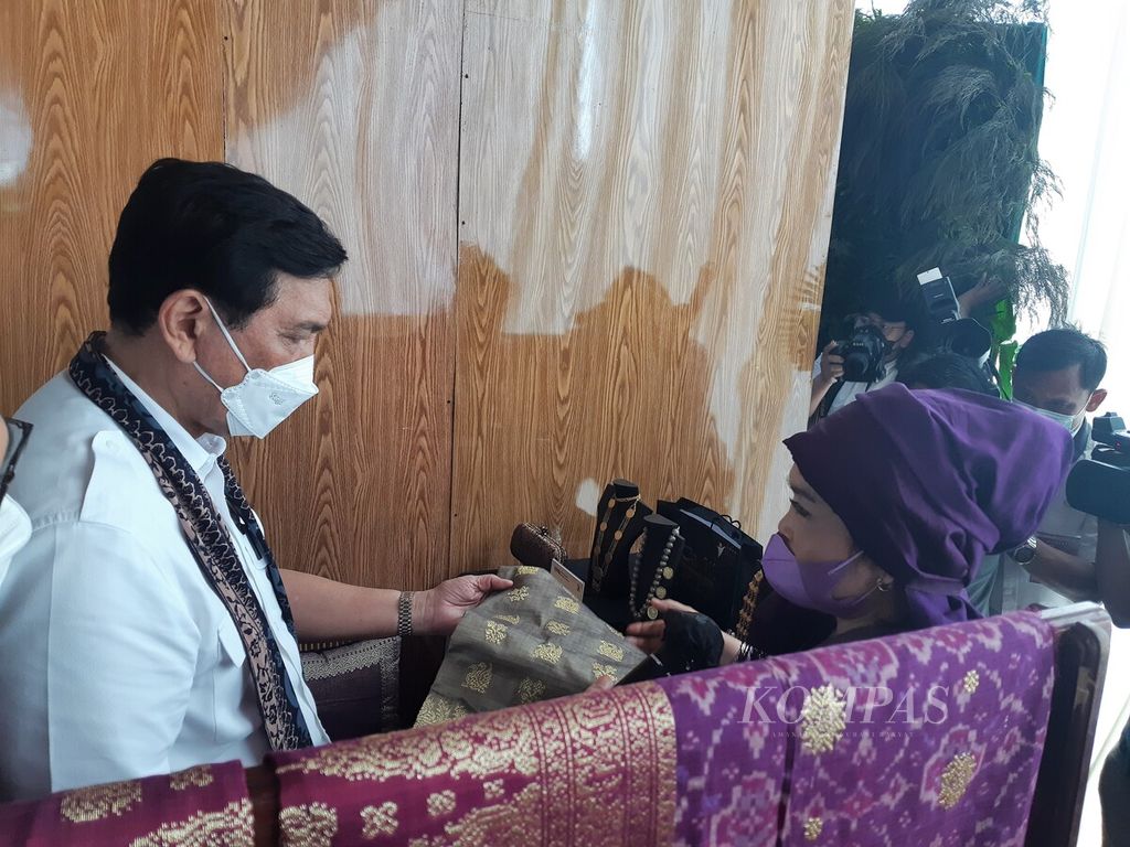 Menteri Luhut Binsar Pandjaitan melihat kain songket produksi Cik Mia dalam peluncuran Bangga Buatan Indonesia di Bandara Sultan Thaha, Jambi, Rabu (19/1/2022). Pemerintah mendorong UMKM tumbuh melesat hingga menjangkau pasar global.