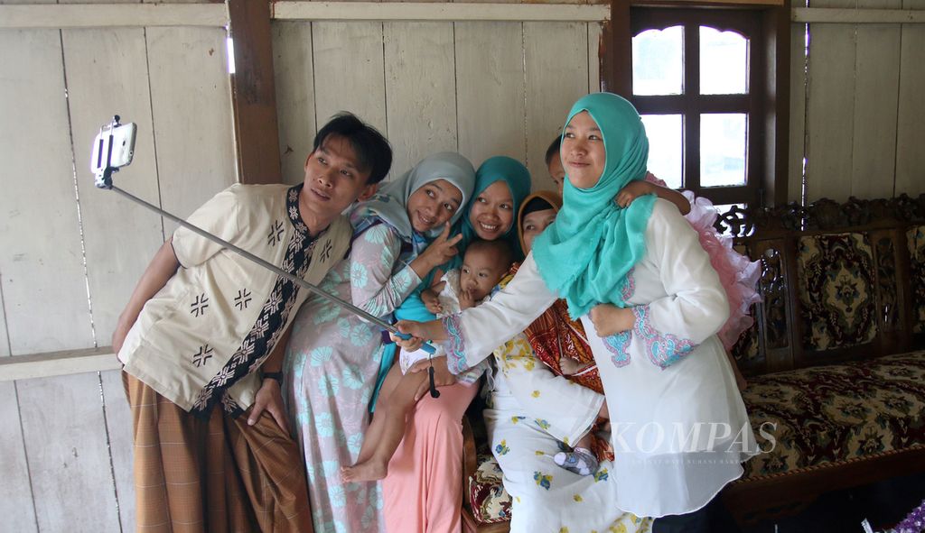 Salah satu keluarga di Lampung Barat mengabadikan diri dengan swafoto saat bersilaturahmi usai shalat Idul Fitri, Jumat (17/7/2015). Lebaran menjadi ajang silaturahmi antarkeluarga, berbagi cerita, dan berbagi rezeki kepada keluarga.