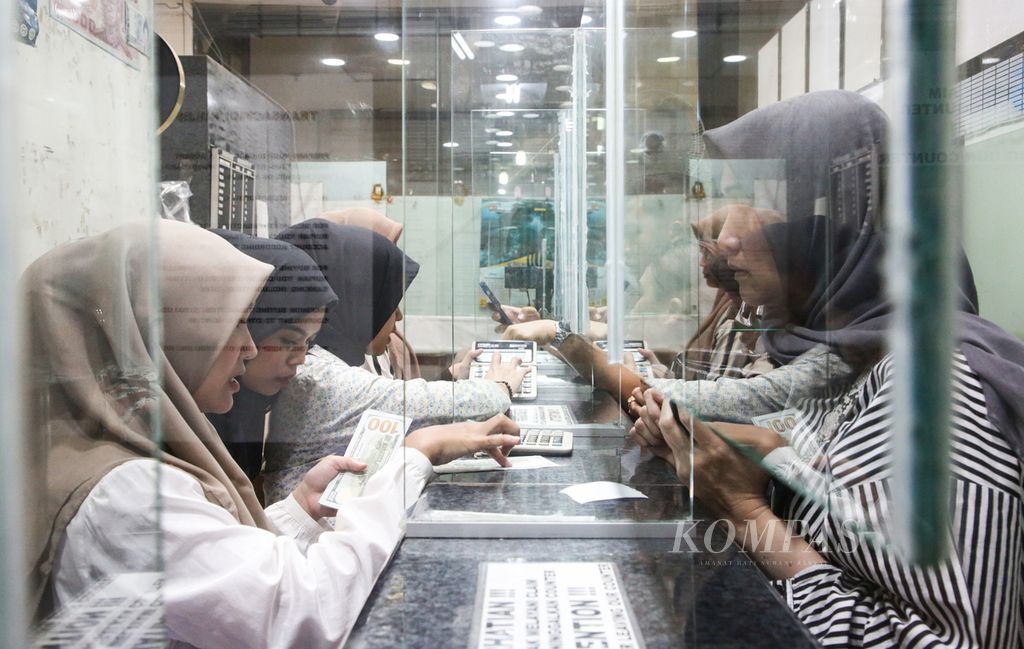 Officers serve foreign exchange transactions at PT Valuta Artha Mas in Jakarta, Tuesday (16/4/2024). The exchange rate of the rupiah was recorded to weaken, breaking through the level of Rp 16,200 per US dollar after the 2024 Eid holiday.