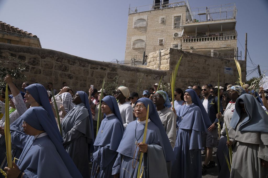 Biarawati mengikuti arak-arakan saat prosesi perayaan Minggu Palma di Jerusalem, Minggu (10/4/2022). Dalam pidato di Sidang Majelis Umum PBB, Raja Abdullah II dari Jordania menyinggung soal ancaman terhadap umat dan warisan sejarah Kristen di Jerusalem.