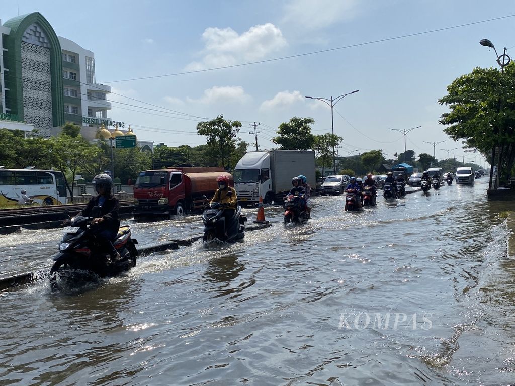 Banjir dengan ketinggian mencapai 30 sentimeter masih merendam Jalan Pantura Kaligawe, Kota Semarang, Jawa Tengah, Senin (8/4/2024). 