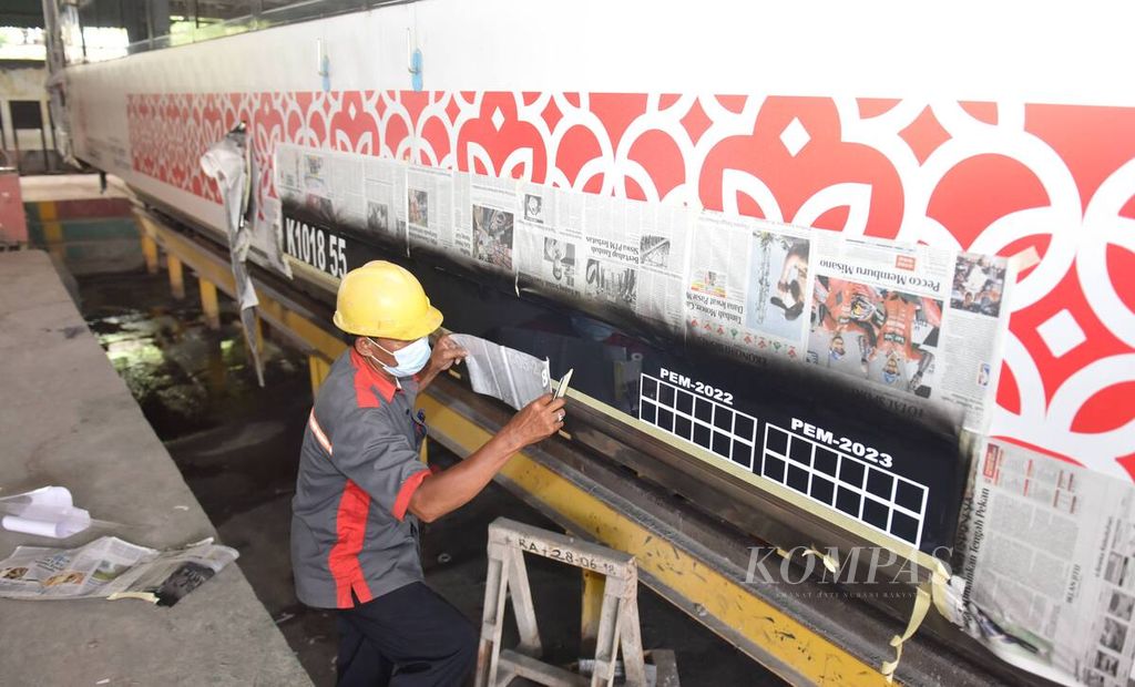 Pekerja menempelkan stiker di gerbong kereta di Balai Yasa Surabaya Gubeng jelang angkutan Lebaran 2022 di Kota Surabaya, Jawa Timur, Senin (11/4/2022). 