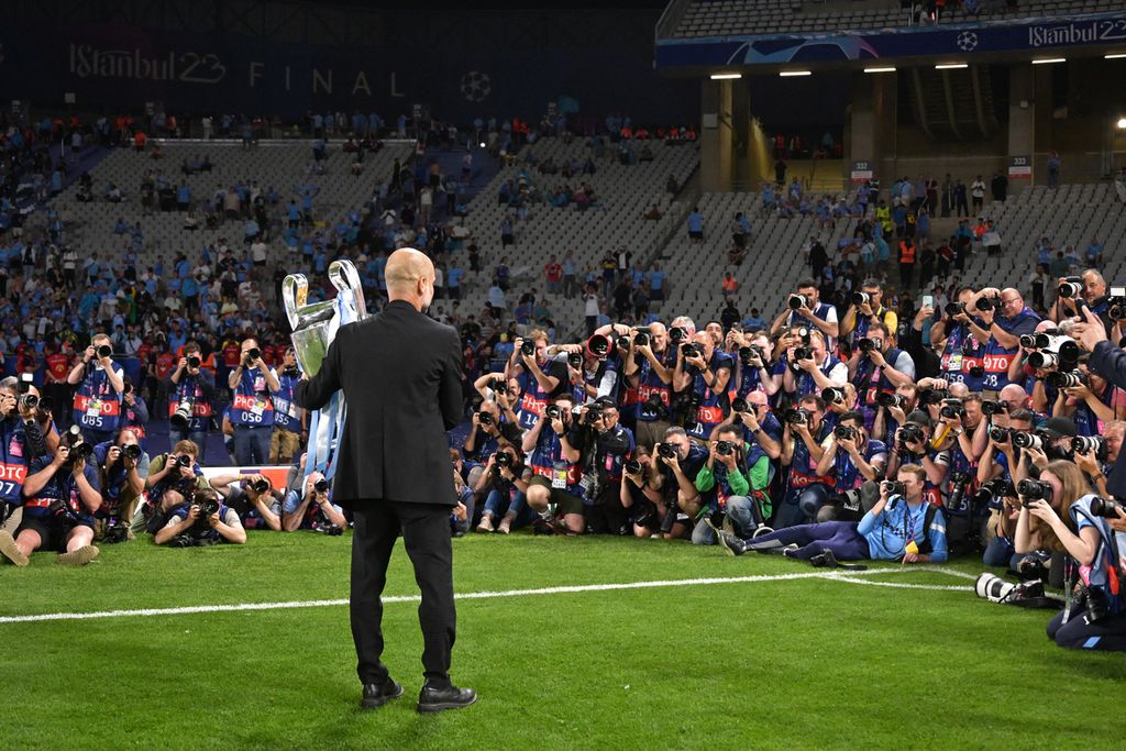 Manajer Manchester City Pep Guardiola berfoto dengan trofi seusai membawa Manchester City menjuarai Liga Champions 2022/2023 di Stadion Olimpiade Ataturk di Istanbul, 10 Juni 2023.