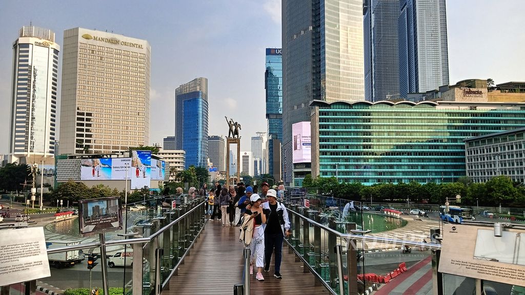 Suasana sore di <i>skydesk </i>Halte Transjakarta Bundaran HI, Kamis (20/6/2024), ramai dikunjungi warga untuk berawal foto dan menikmati lanskap jantung Kota Jakarta dengan monumen ikonik bersejarah Patung Selamat Datang.