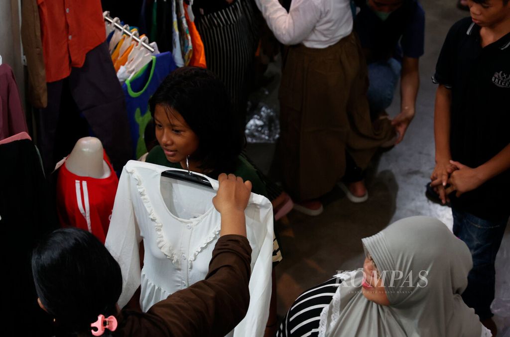 Ibu yang memilihkan baju terbaik bagi anaknya untuk merayakan Idul Fitri saat mereka berbelanja di Pasar Johar, Kota Semarang, Jawa Tengah, Minggu (7/4/2024). 
