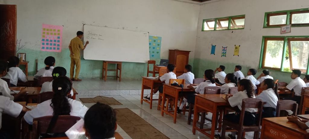 Petrus Poli Kayan, guru honorer di SMPN Baniona, Flores Timur, Kamis (25/5/2023), mengajar Bahasa Inggris di depan siswa kelas VIII. 