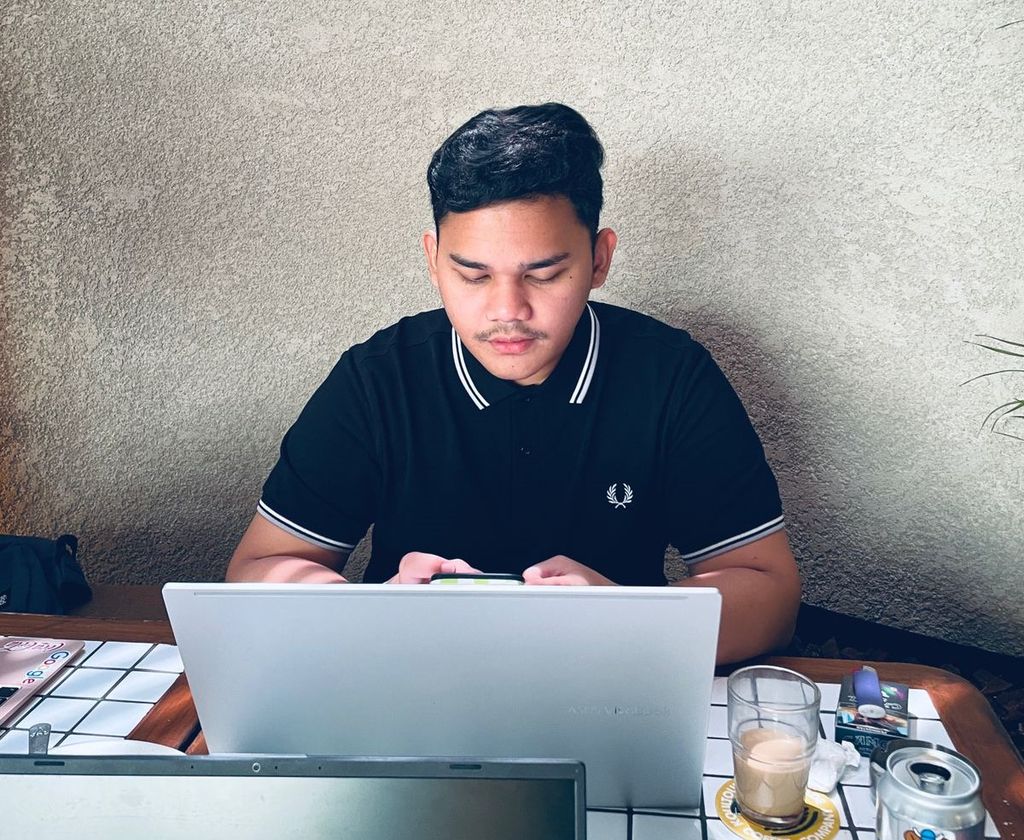 Ario Wibowo sedang mengerjakan tugas di sebuah kafe di daerah Senopati, Jakarta Selatan.