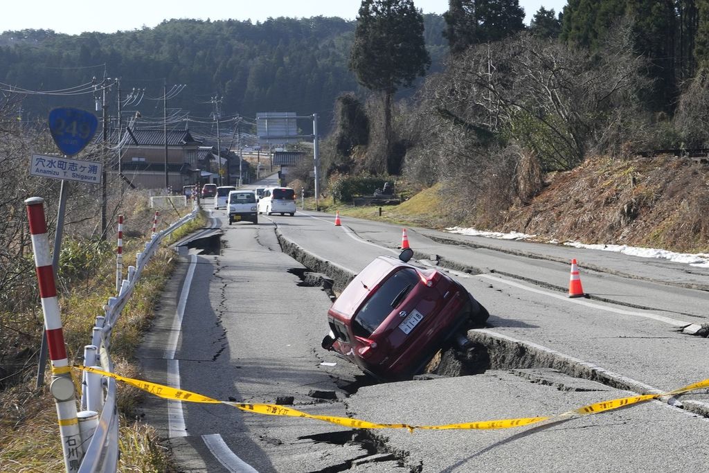 Sebuah mobil terperangkap di bongkahan jalan yang amblas akibat gempa di dekat Kota Anamizu, Prefektur Ishikawa, Jepang, Selasa (2/1/2024). 