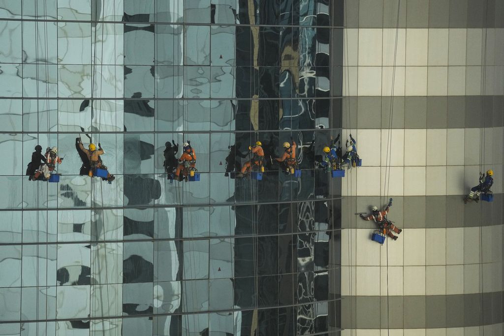 Pekerja membersihkan dinding kaca sebuah gedung di Distrik West Bay, Doha, Qatar, Sabtu (17/12/2022). 