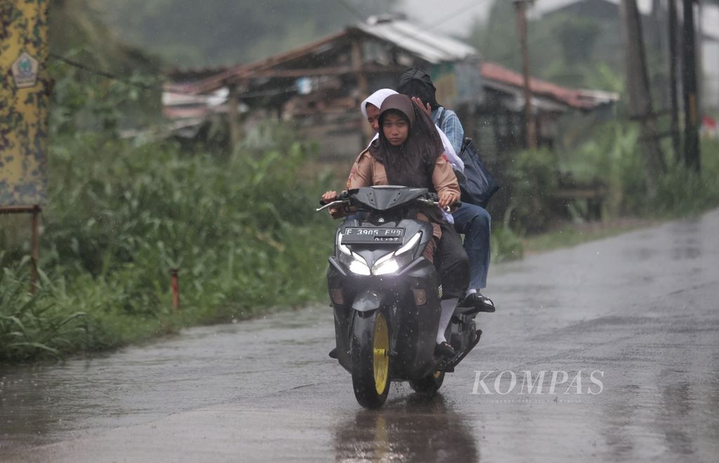 Siswa SMA menembus hujan deras saat pulang sekolah di kawasan Ciampea, Bogor, Jawa Barat, Selasa (14/11/2023). 