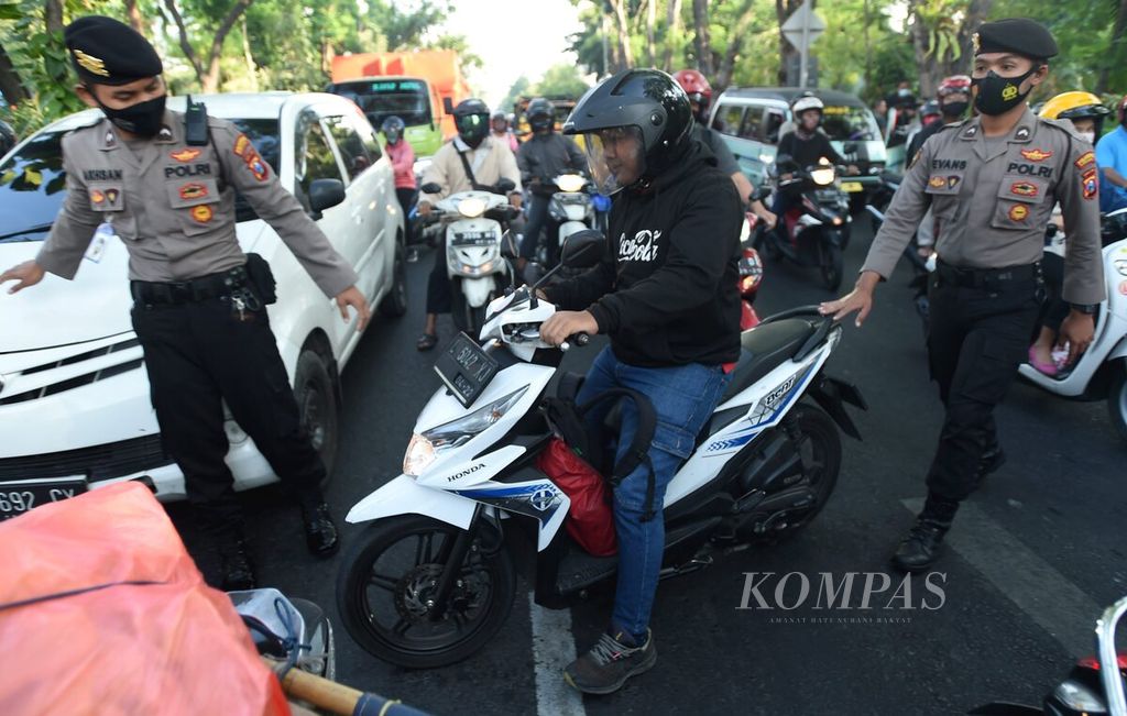 Petugas menindak pengendara yang tidak menggunakan masker saat Operasi Yustisi Pelanggar Protokol Kesehatan di Jalan Darmo, Surabaya, Senin (14/9/2020). 
