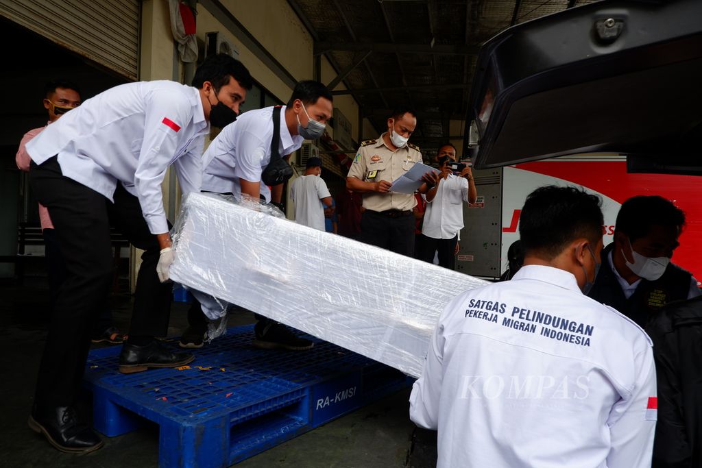 Petugas menaikkan jenazah warga Lombok, Nusa Tenggara Barat, ke mobil ambulans begitu tiba di Bandara Internasional Lombok, NTB, Rabu (5/1/2022). Warga Lombok tersebut meninggal dalam kecelakaan kapal pengangkut pekerja migran Indonesia ilegal di perairan Johor, Malaysia.